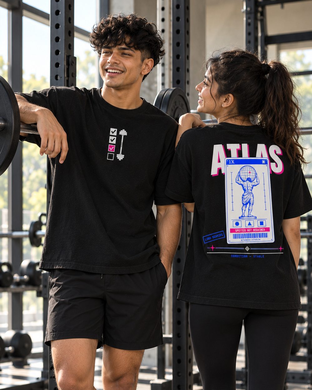 Two people in Atlas tees leaning on a rack, chest print and back print