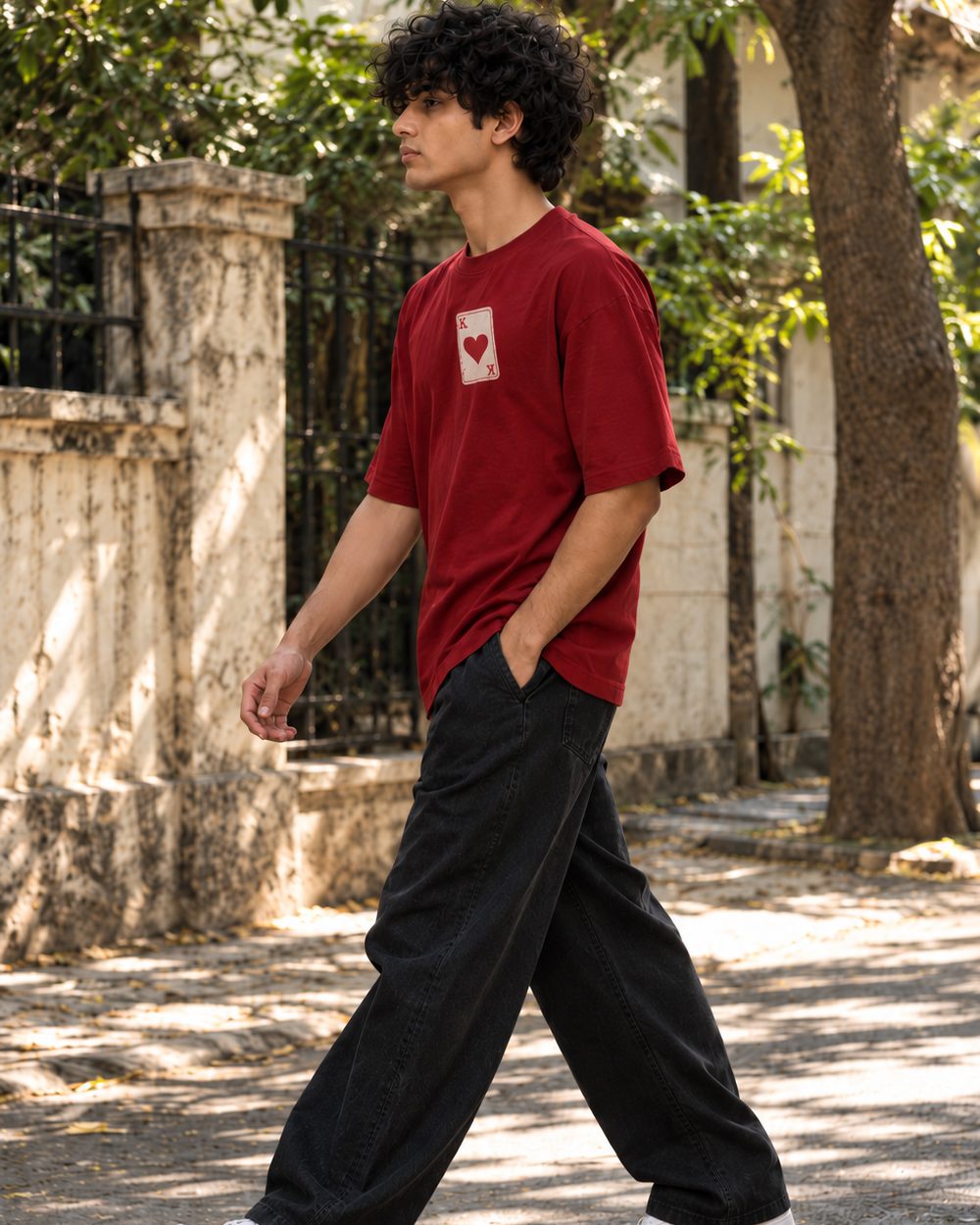 Face Card tee in maroon, heart card chest print, walking down a tree-lined lane